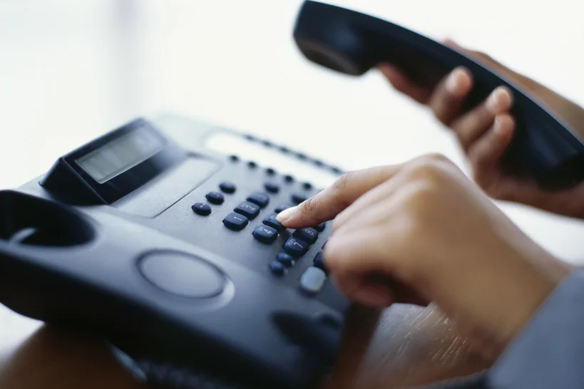Telefonische-Beratung - Telefon, eine Hand wählt eine Nummer