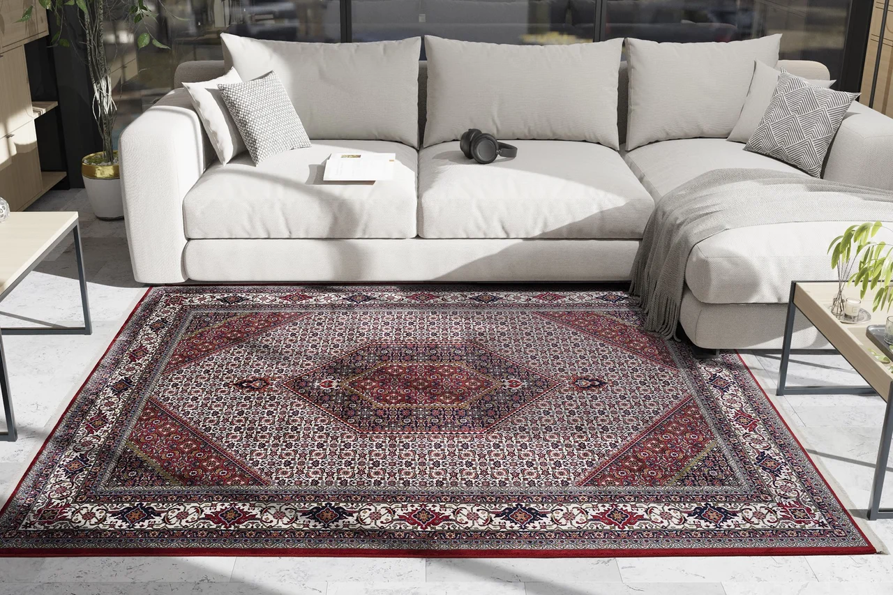 Ein traditioneller, klassischer, roter Orientteppich liegt im Wohnzimmer auf dem Boden. - Ein traditioneller, klassischer, roter Orientteppich liegt im Wohnzimmer auf dem Boden.